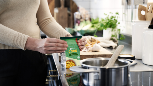 envases carton bebidas esenciales evitar desperdicio alimentos Mujer con un envase de cartón para bebidas cocinando