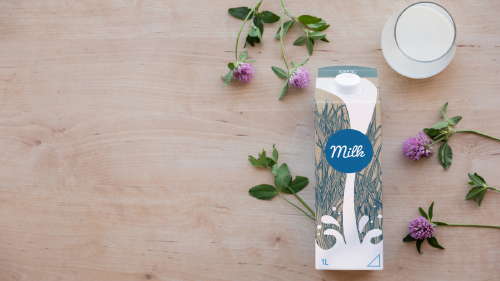 como recicla envase carton leche Cartón y vaso de leche y flores sobre fondo de madera